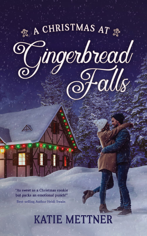 "The background of the cover is a snowy night with a brown cottage decorated with Christmas lights. There is a couple on the righthand side hugging, and the woman's leg is popped up into the air. She is wearing a white hat, a brown coat, blue jeans and brown boots. he is wearing a black stocking cap, denim jacket, and denim jeans. The top says A Christmas at Gingerbread Falls. The bottom says Katie Mettner."
